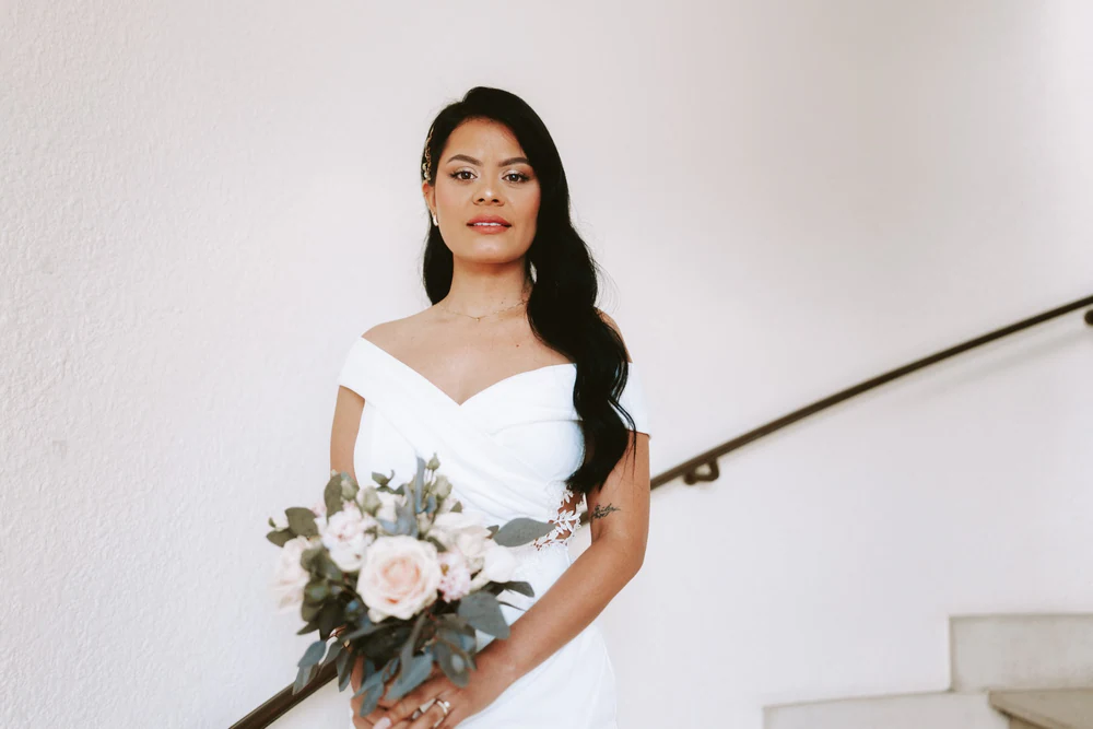 La mariée tenant son bouquet dans la cage d'escalier, mariage à Bouillon