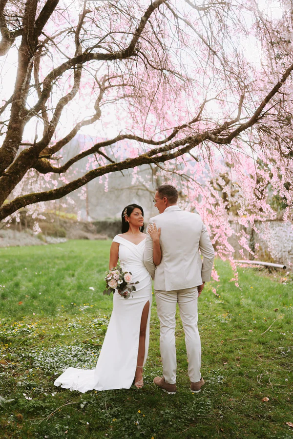 Les mariés de dos sous un cerisier en fleurs, mariage à Bouillon