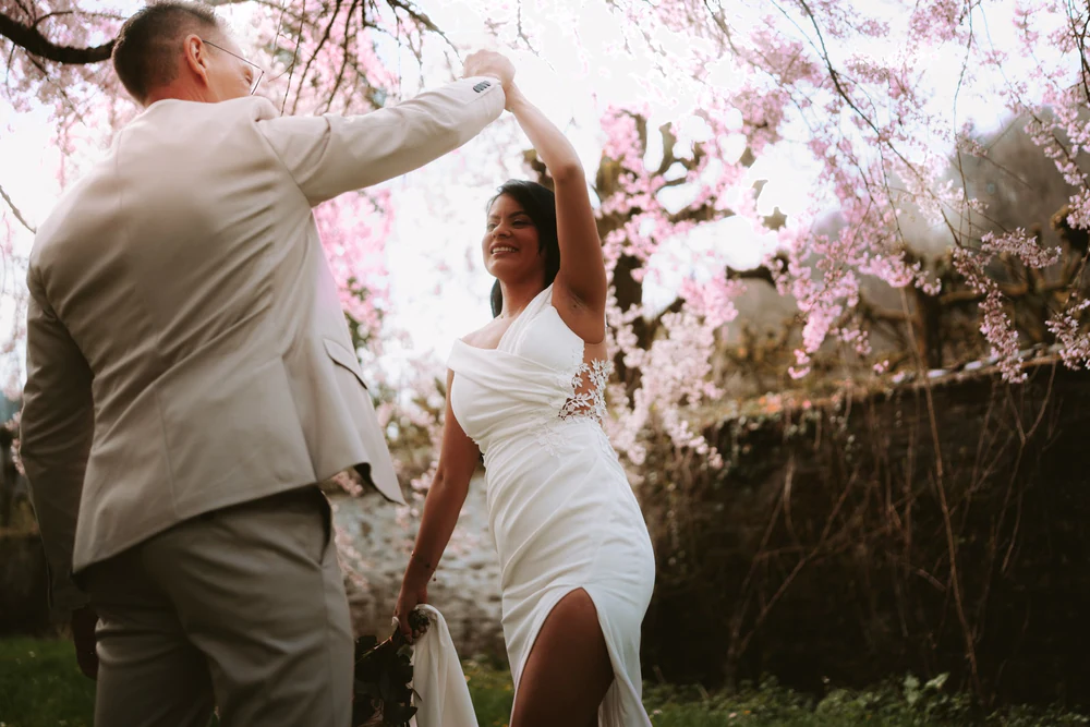 Le marié fait tourner la mariée sous les cerisiers en fleurs, mariage à Bouillon