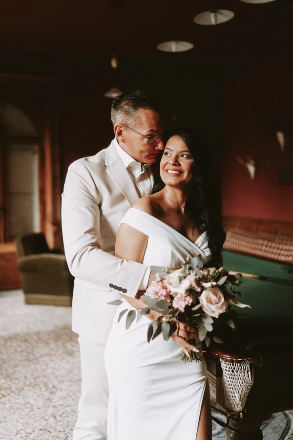 Les mariés enlacés dans la salle de billard, mariage à Bouillon