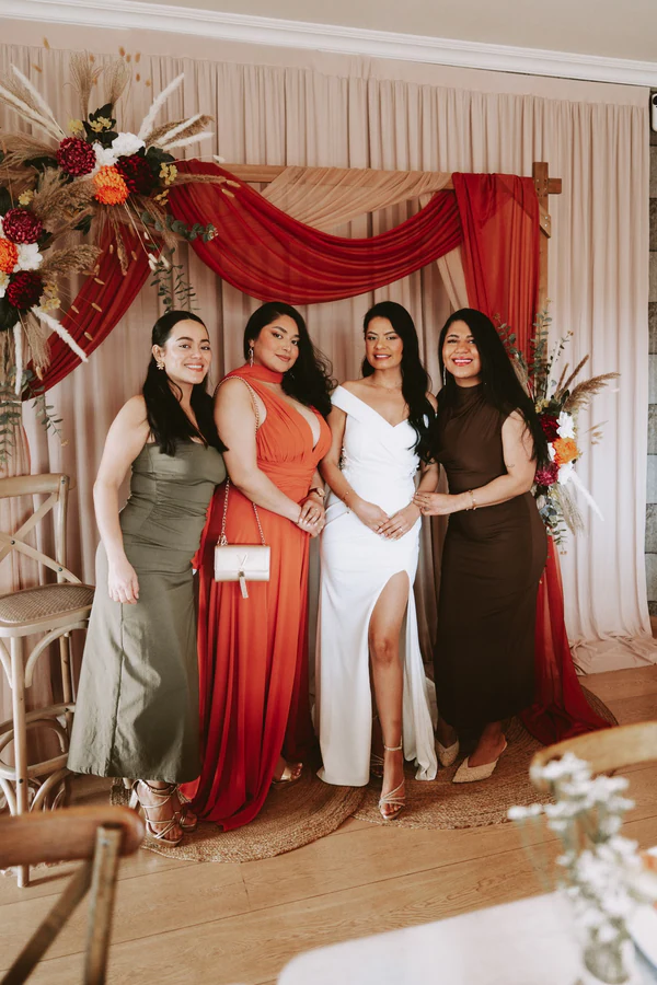 La mariée et trois amies devant une décoration rouge et fleurie, mariage à Bouillon