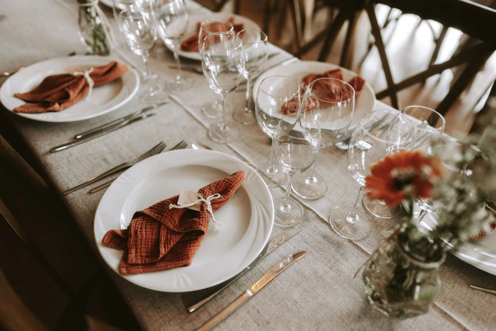 Assiettes et serviettes terracotta sur la table de réception, mariage à Bouillon