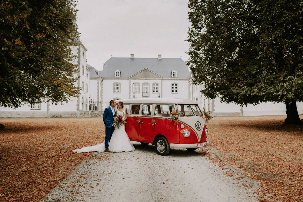 Les mariés devant le combi Volkswagen rouge et le Château de Deulin