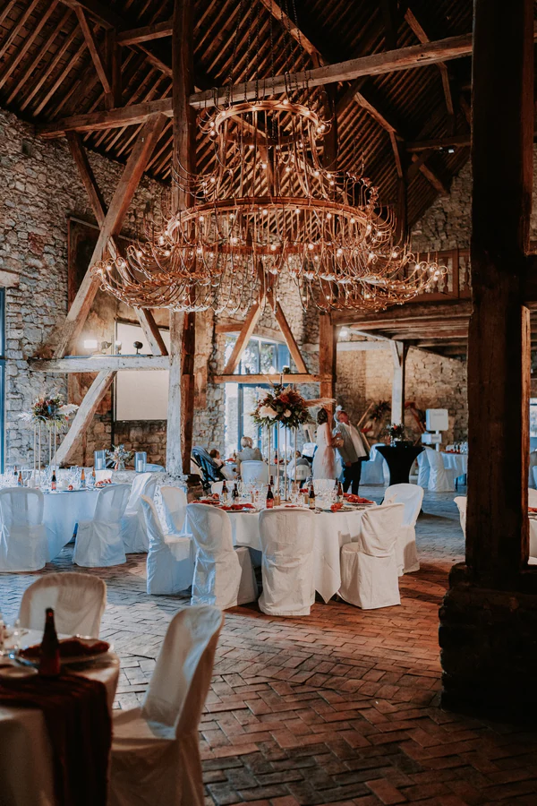 La grange du château décorée pour la réception, grand lustre, mariage à Deulin