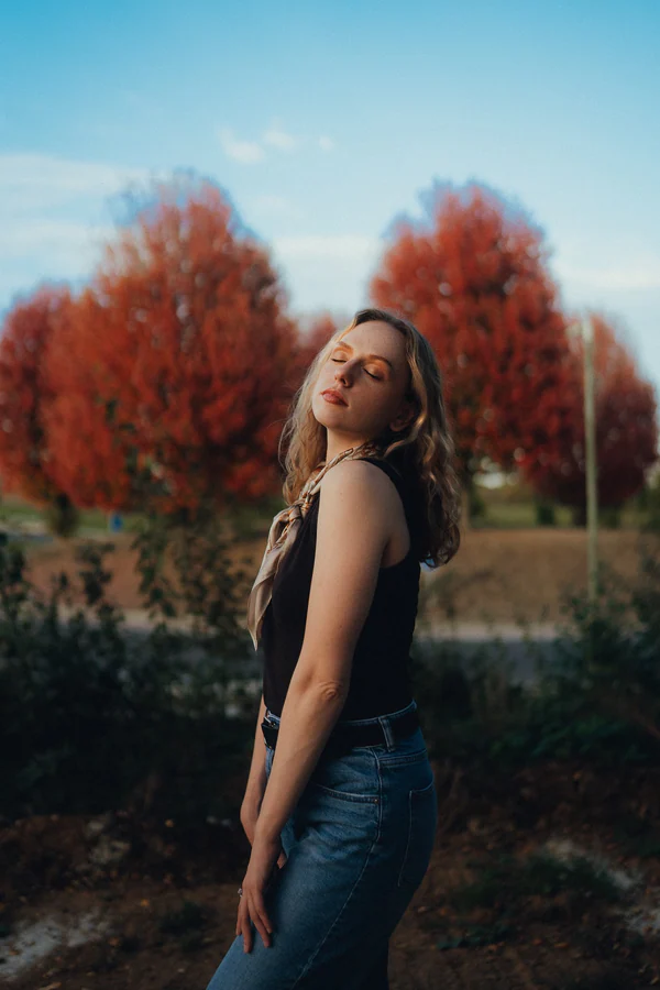 Portrait de Chloé de profil, tête en arrière et yeux fermés, lumière dorée d'automne, par Gautier Collet