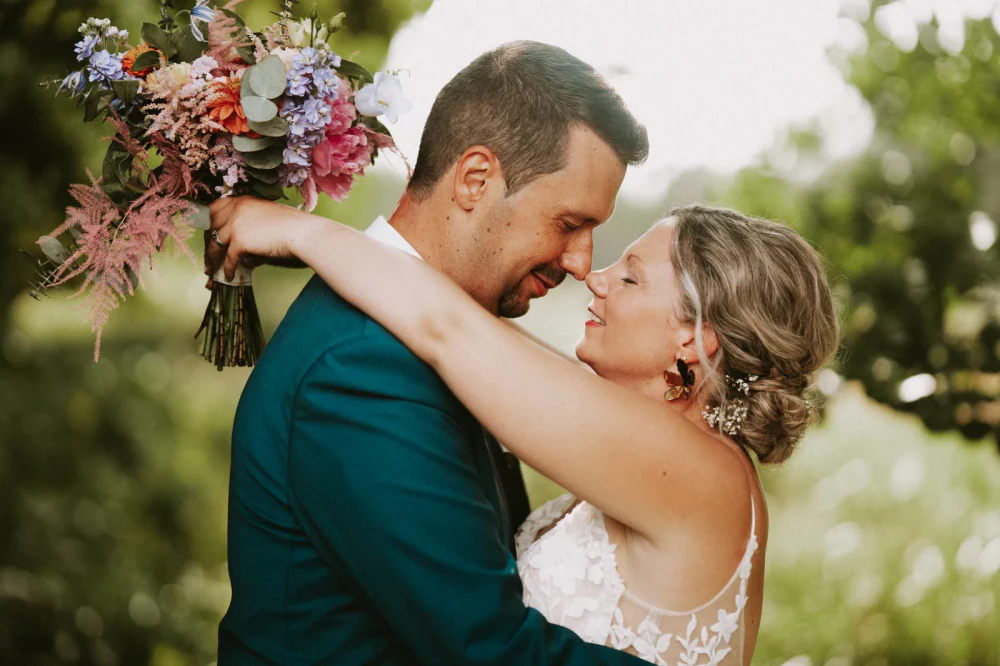 Mariés front contre front avec un bouquet coloré, tarifs photographe mariage Belgique, Luxembourg et France